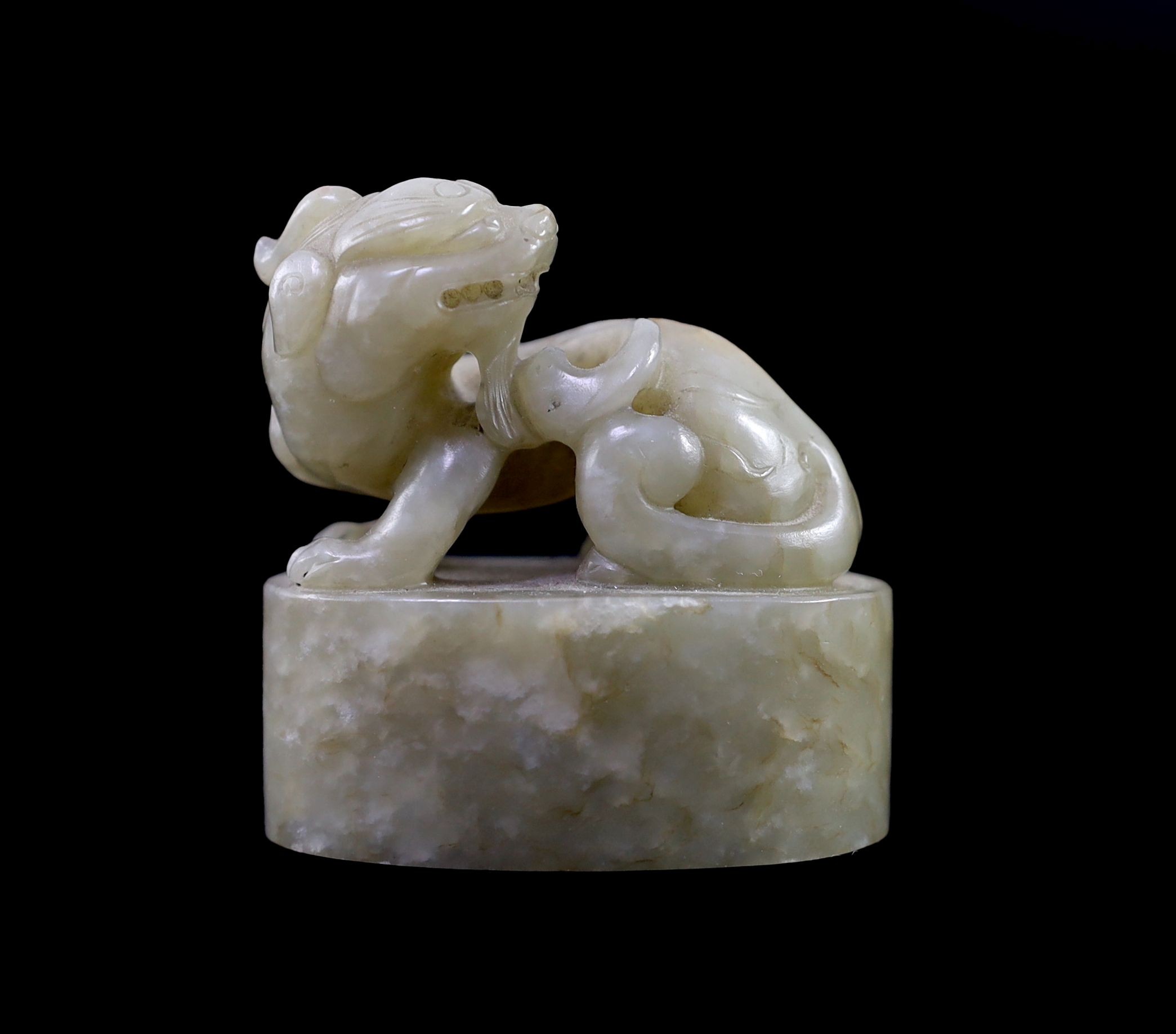 A Chinese celadon and white mottled jade ‘lion-dog’ seal, 18th/19th century, 6cm long